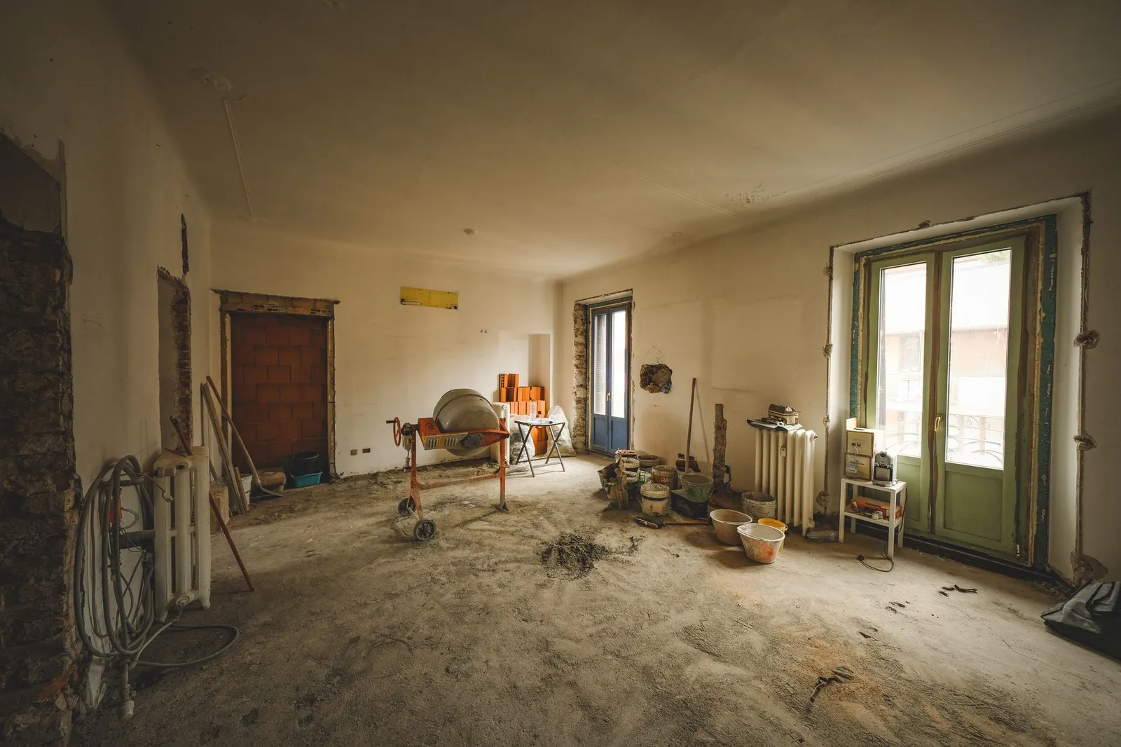 Wohnung im Rohzustand mit Baumaterial und Werkzeug auf dem Boden